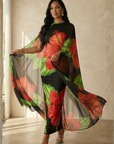 Woman wearing a floral dress with a sheer overlay in a neutral setting