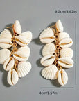 Shell earrings with measurements on a gray background