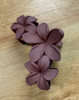 Purple floral hair clip on a wooden surface