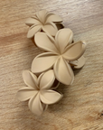 Beige floral hair clip on a wooden surface