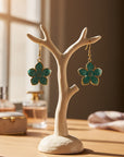 Turquoise flower-shaped earrings with gold accents on a white background