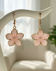 Flower-shaped earrings with gold accents on a white background