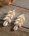 Shell and pearl earrings on a wooden surface