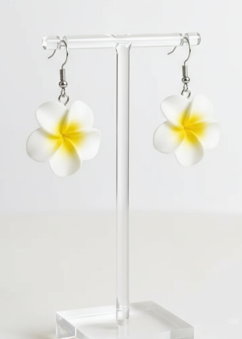 Flower-shaped earrings on a white fabric background