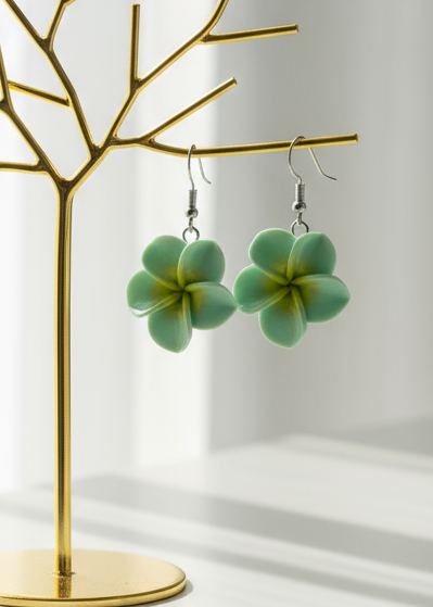 Green flower-shaped earrings on a white background