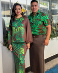 Two people in matching green and brown leaf-patterned outfits standing indoors.