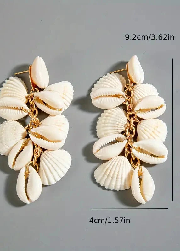 Shell earrings with measurements on a gray background