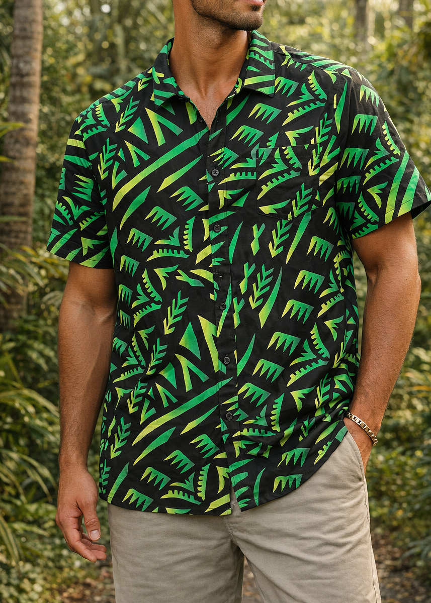 Man wearing a green and black patterned shirt in a tropical setting
