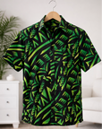 Green and black patterned shirt on a hanger against a white wall.