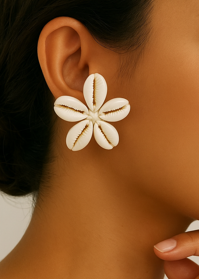 Close-up of a woman wearing a shell flower earring against a neutral background