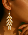 Close-up of a woman wearing elegant pearl earrings with a blurred background