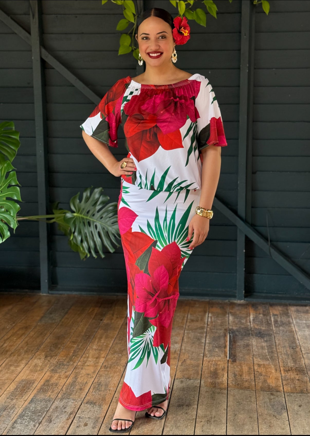 Woman wearing a colorful floral dress with a dark wooden background