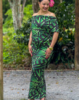 Woman wearing a green and black patterned dress outdoors.