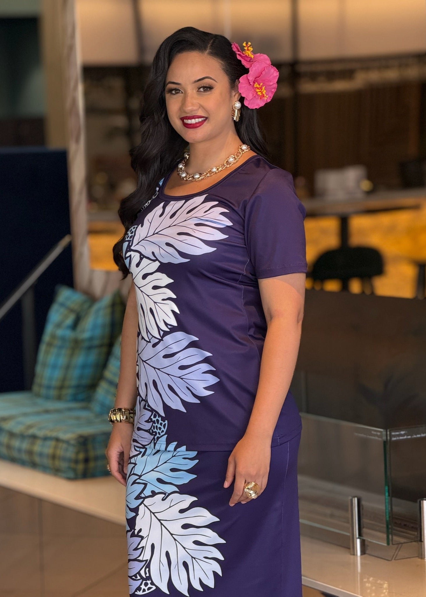 Woman wearing a purple dress with leaf patterns indoors