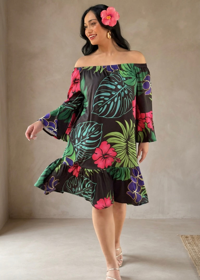 Woman wearing a colorful floral dress against a plain background