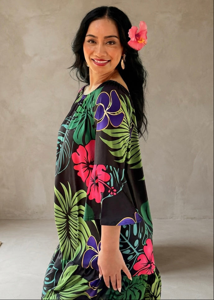 Woman wearing a colorful floral dress against a plain background