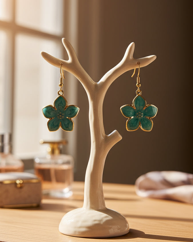 Turquoise flower-shaped earrings with gold accents on a white background