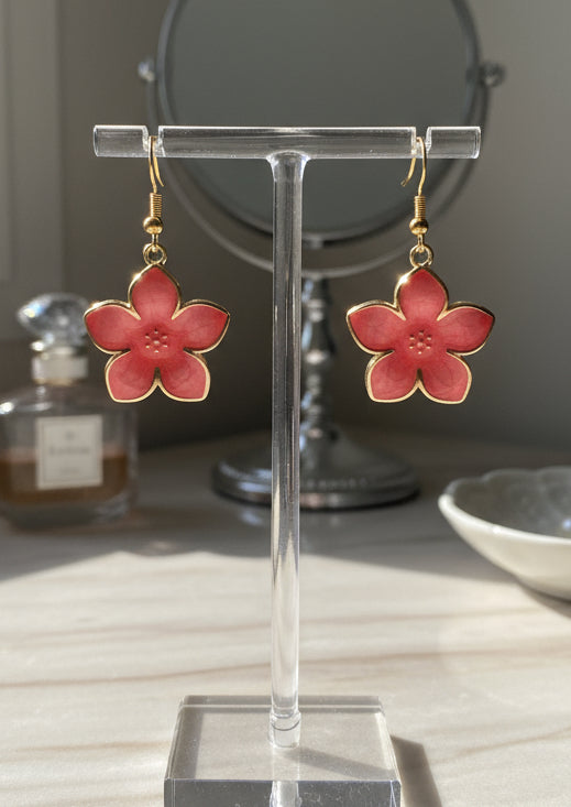 Pink flower-shaped earrings on a white background