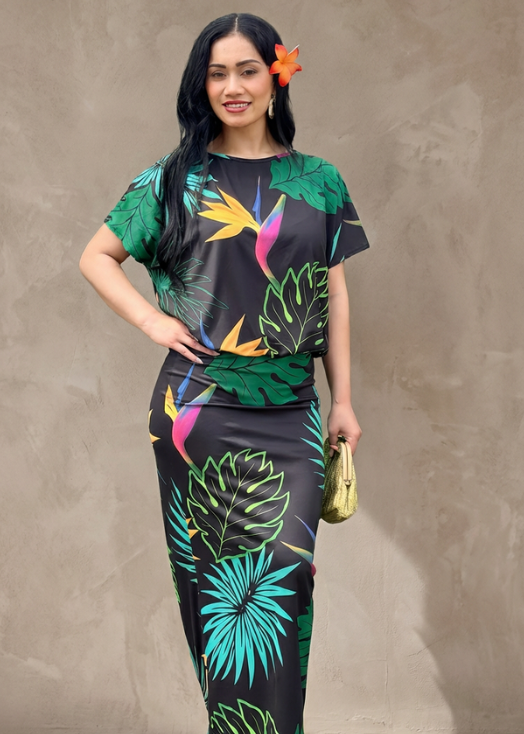Woman wearing a colorful tropical-themed outfit against a plain background