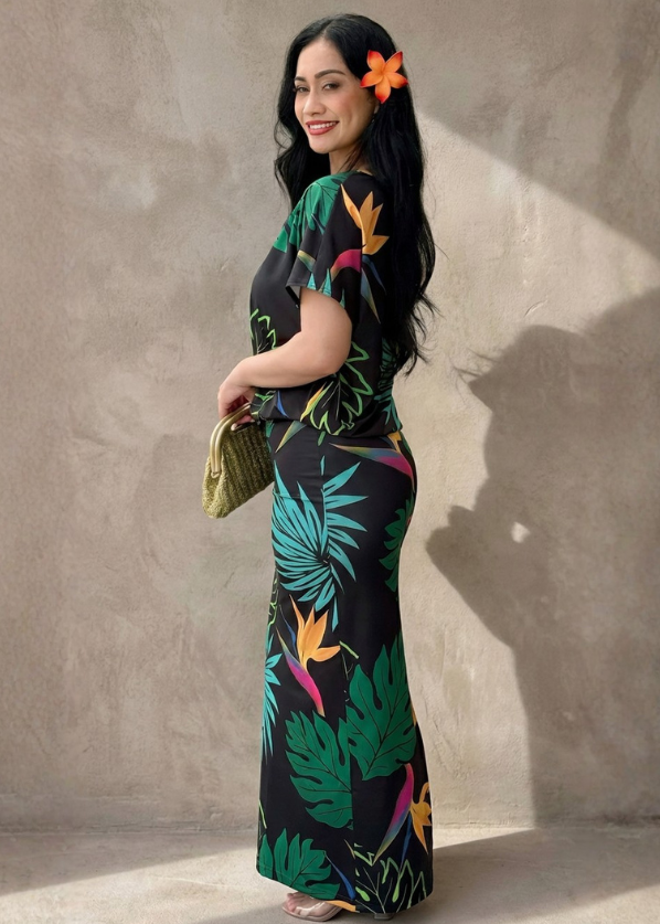 Woman wearing a colorful floral dress against a plain wall