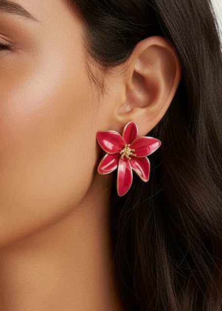 Pair of red flower-shaped earrings on a dark surface