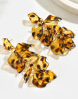 Tortoiseshell floral earrings on a white background